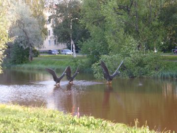 3 statues of bird on the river
